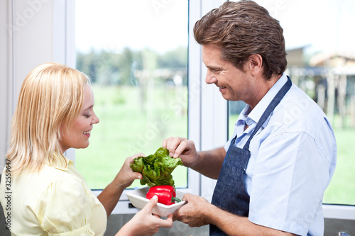Photo: Mature couple in kitchen preparing healthy food Mature couple in kitchen preparing healthy food