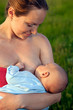 Young woman breastfeeding her baby outdoors