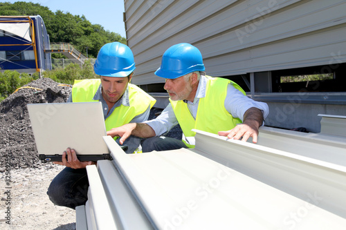 Photo: Construction workers checking building material Construction workers checking building material