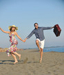 couple on beach with travel bag