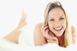 Cheerful young lady lying on the bed
