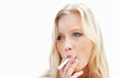 Young female smoking a cigarette against white background