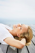 Happy young girl lying relaxed on a wooden porch
