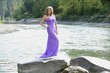 woman in a formal dress standing on a rock;troutdale,oregon,USA