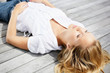 Young female lying relaxed on a wooden porch