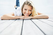 Happy pretty female lying down on a wooden porch