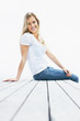 Happy young female sitting on a wooden porch