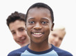 Closeup of a teenaged black boy with friends at the back