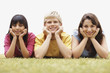 Group of a teenagers lying on grass in a line