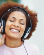 Foto: Closeup of a happy young girl enjoying music over headphones Closeup of a happy young girl enjoying music over headphones