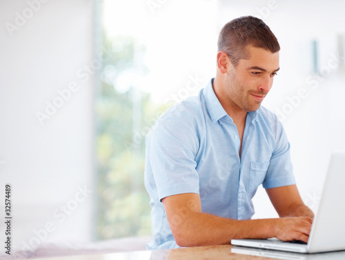 Foto: Confident young man working on laptop - Copyspace Confident young man working on laptop - Copyspace