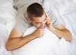 Photo: Happy young guy talking on mobile while lying on bed Happy young guy talking on mobile while lying on bed