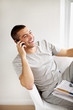 Foto: Casual young guy enjoying conversation on mobile Casual young guy enjoying conversation on mobile