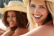 Foto: Closeup of a pretty young woman at the beach with friends Closeup of a pretty young woman at the beach with friends