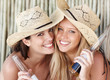 Happy young females with beer bottles, beach view