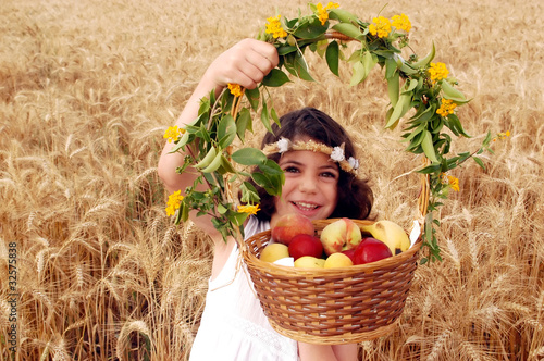 Photo: Girl Holds Basket of Fruit in Field of Wheat Girl Holds Basket of Fruit in Field of Wheat