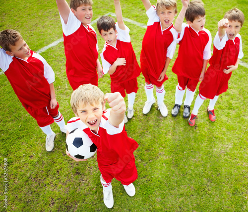 Photo: Top view of confident soccer team wearing red colored uniform Top view of confident soccer team wearing red colored uniform