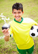 Happy little soccer player holding up his trophy