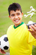 Closeup of a soccer player holding trophy and football