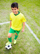 Happy young boy with foot on soccer ball