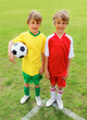 Little rival soccer players standing together on playground