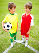 Little rival football players looking at each other on field