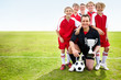 Soccer team with coach holding trophy on field - copyspace