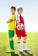 Two rival soccer kids standing back to back on field