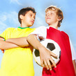 Two football rival players staring at each other against sky
