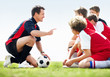 Side view of little soccer players listening to their coach