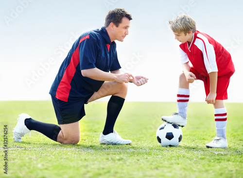Foto: A coach instructing a soccer kid on field A coach instructing a soccer kid on field
