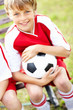 Closeup portrait of a cute happy soccer kid holding a ball