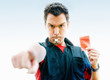 Soccer referee pointing at you while holding out a red card