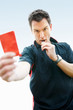 Football referee showing you the red card against sky