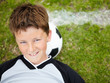 Smiling little soccer player relaxing head on the ball