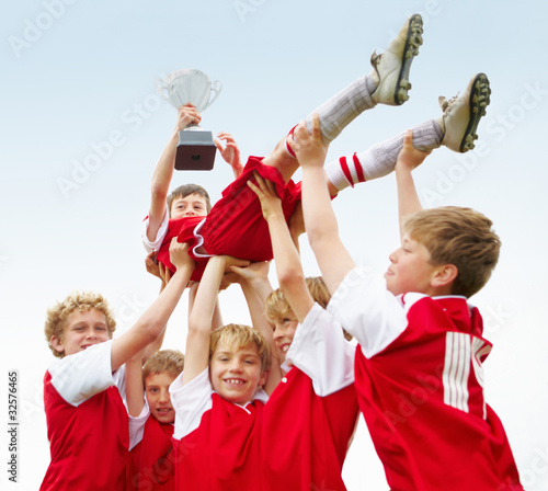 Photo: Soccer team lifting their captain after a match victory Soccer team lifting their captain after a match victory