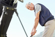 A smiling mature man playing golf