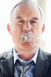 Closeup of a smart business executive smoking cigar
