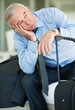 Relaxed mature business man with his luggage while looking away