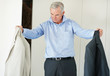 Mature man looking at suit while getting ready for office