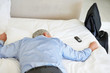 Overworked senior business man lying in bed