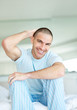 Happy middle aged man with hand behind head at home