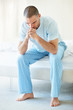 Tensed middle aged man with hands on chin while sitting in bed