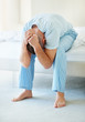 Frustrated man with hands on head while sitting in bed