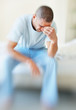Middle aged man suffering from a severe headache holds his head