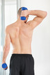 Rear view of a strong man using dumbbells