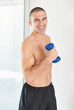 Middle aged muscular man lifting weights smiling