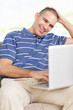 Happy middle aged man sitting while working on laptop