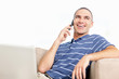 Happy middle aged man with laptop while talking on mobile phone