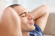 Relaxed middle aged man with eyes closed and hands behind head